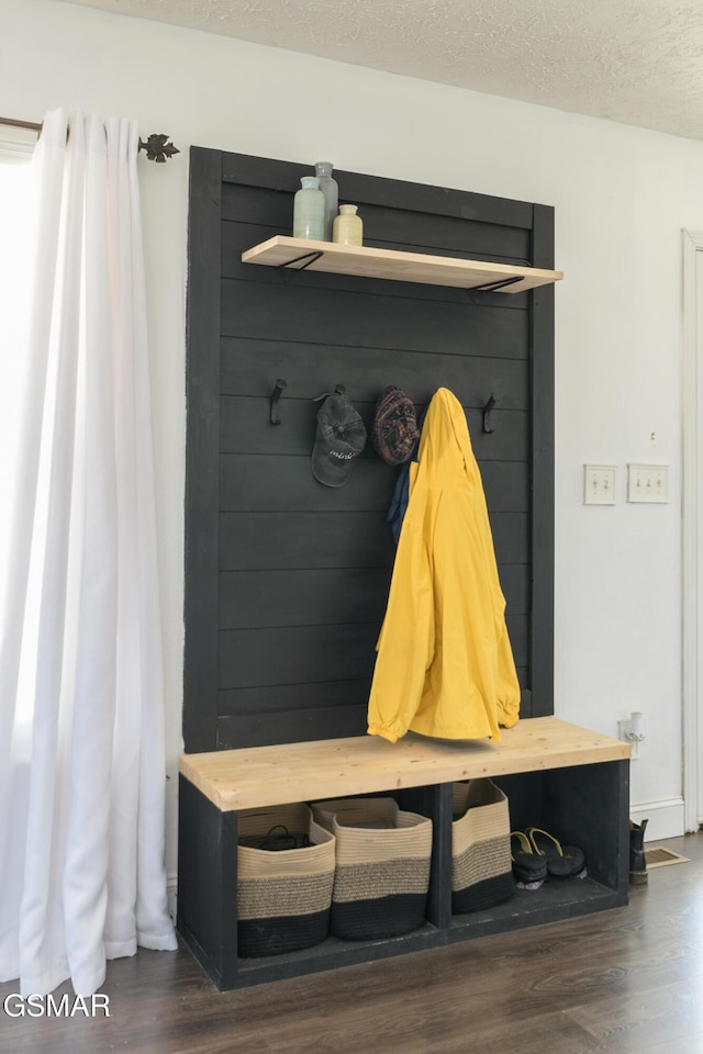 mudroom with a textured ceiling and wood finished floors