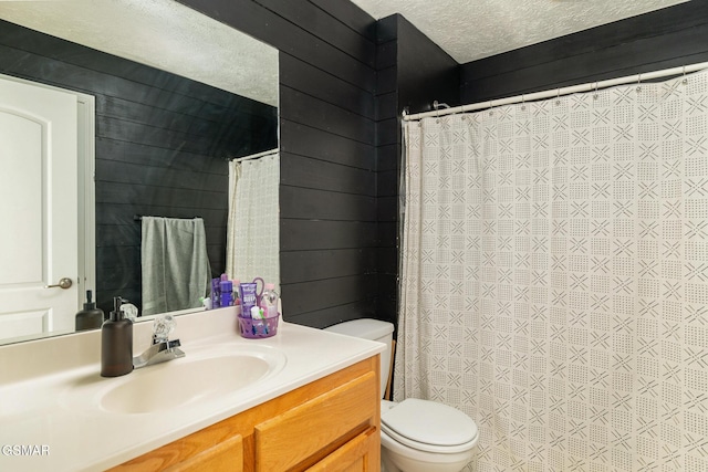 full bath with a textured ceiling, curtained shower, toilet, wooden walls, and vanity