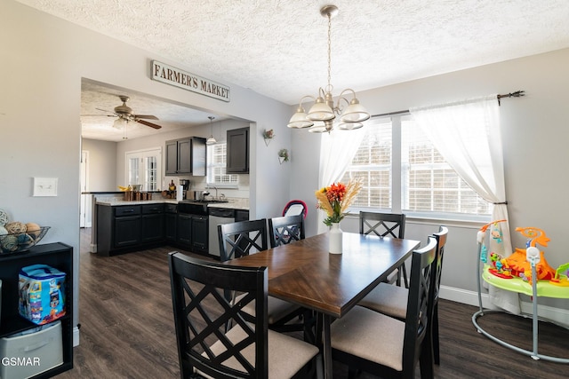 dining space featuring dark wood-type flooring, a textured ceiling, baseboards, and an inviting chandelier