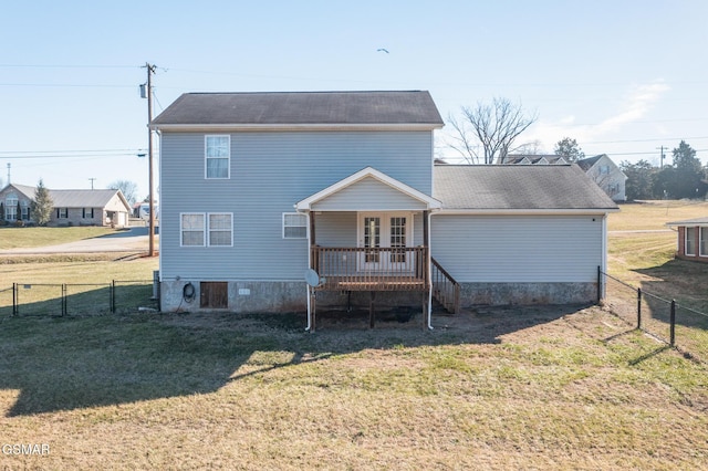 rear view of house featuring a lawn and fence