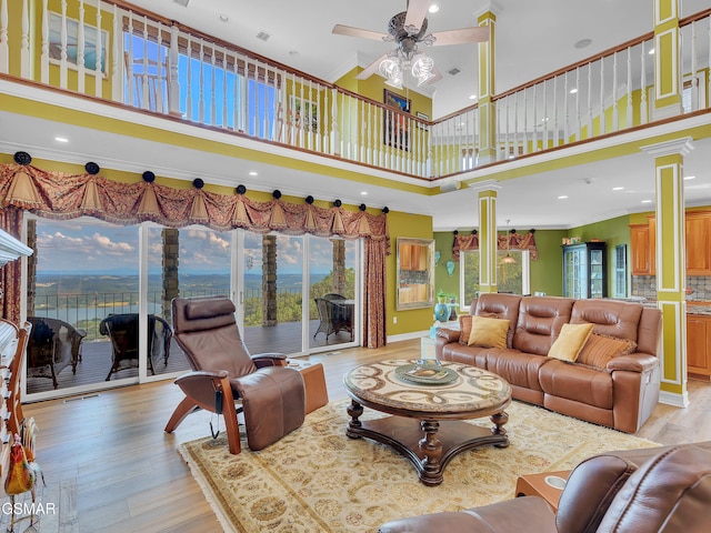 498 Proffitt Ridge Rd, Mooresburg, TN 37811 - living area with decorative columns, ceiling fan, a towering ceiling, crown molding, and light wood-style floors