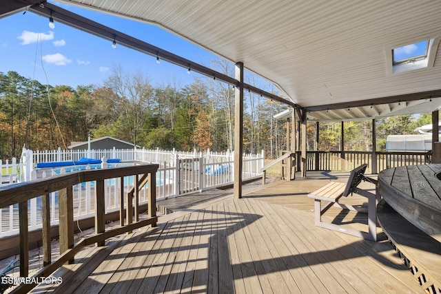 wooden deck with a fenced in pool