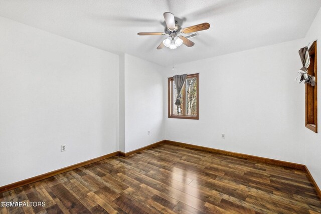 empty room featuring dark wood-type flooring and ceiling fan