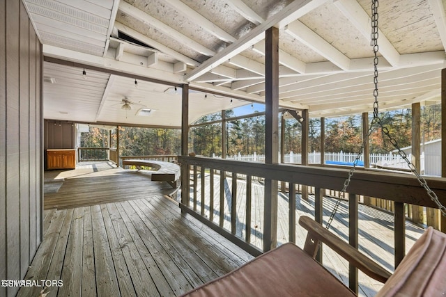 deck with ceiling fan and a water view