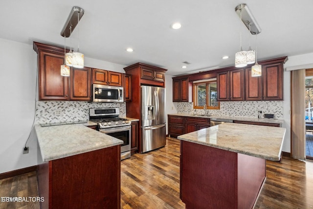 kitchen with sink, stainless steel appliances, dark hardwood / wood-style flooring, and hanging light fixtures