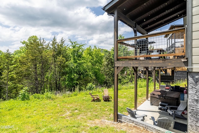 view of yard with a hot tub, a patio area, and a wooden deck
