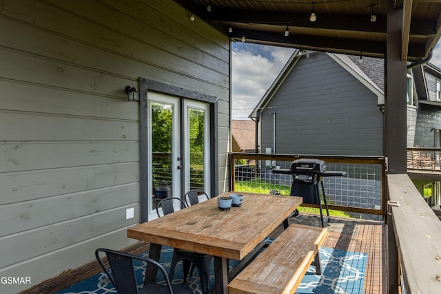 deck with french doors, outdoor dining area, and grilling area