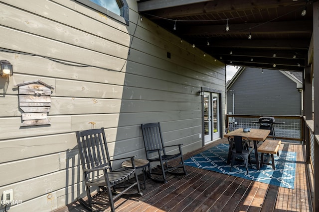 wooden deck featuring outdoor dining space and french doors