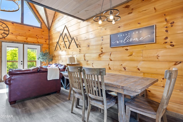 dining area with wooden walls, wood finished floors, french doors, lofted ceiling, and wooden ceiling