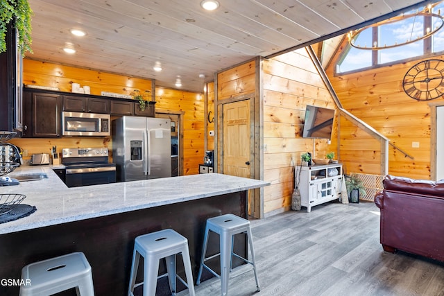 kitchen featuring appliances with stainless steel finishes, dark brown cabinetry, wood finished floors, wooden ceiling, and recessed lighting