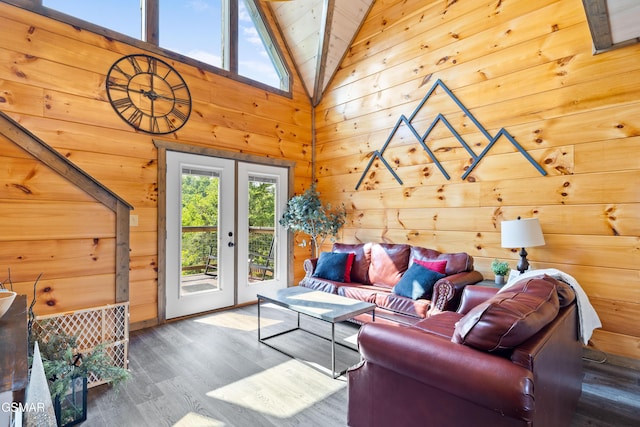 living room featuring wooden walls, wood finished floors, and vaulted ceiling