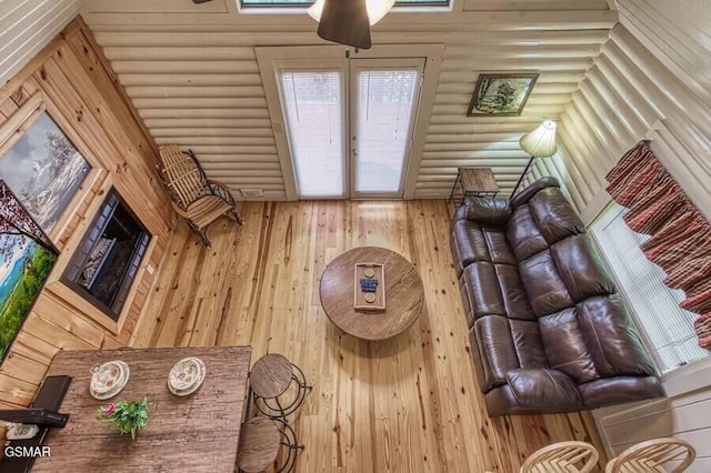 living room with log walls and ceiling fan