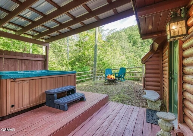 deck with a hot tub and an outdoor fire pit