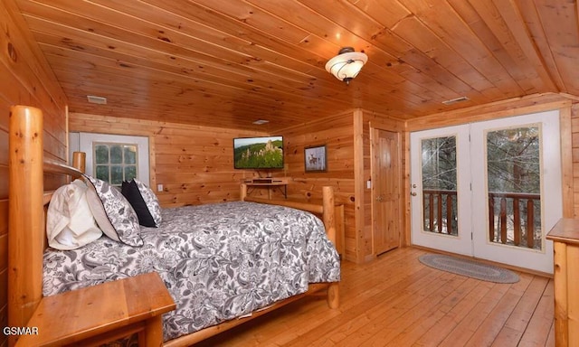 bedroom with access to exterior, wooden walls, multiple windows, and wooden ceiling