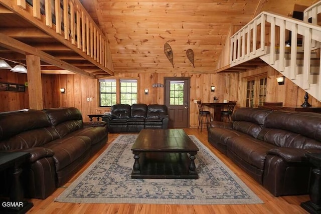 living room featuring wooden walls, light hardwood / wood-style flooring, high vaulted ceiling, and wood ceiling