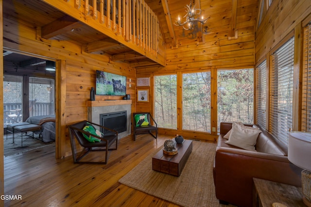3214 Bear Country Way, Sevierville, TN 37876 - living area featuring wood ceiling, wood-type flooring, a tiled fireplace, a chandelier, and wood walls