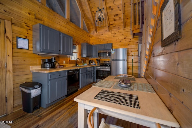 3214 Bear Country Way, Sevierville, TN 37876 - kitchen with stainless steel appliances, a sink, wooden walls, dark wood-style floors, and light countertops