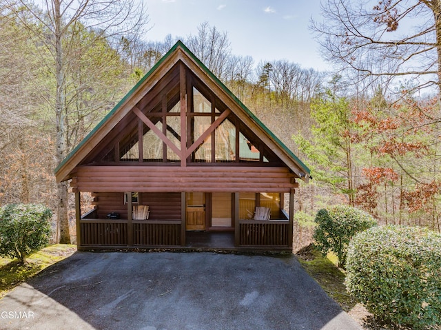 3214 Bear Country Way, Sevierville, TN 37876 - cabin with a porch, log siding, and a forest view