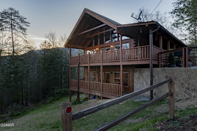 back of property at dusk featuring a deck