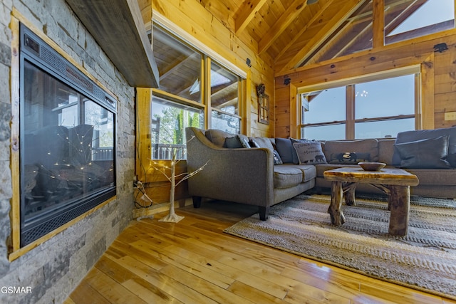 living area with hardwood / wood-style flooring, wooden walls, vaulted ceiling with beams, and wood ceiling