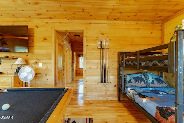 bedroom featuring wood ceiling, light wood-type flooring, and wood walls