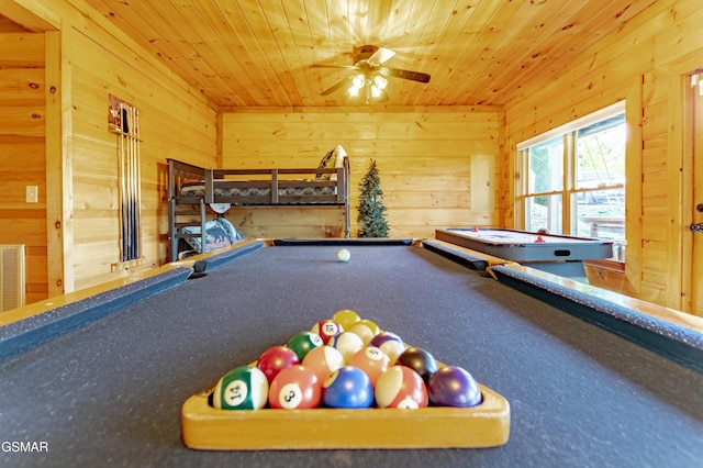 playroom with wood walls, wooden ceiling, and a ceiling fan