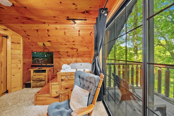 interior space with carpet flooring, lofted ceiling, wooden walls, and wooden ceiling