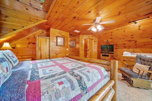 carpeted bedroom with ceiling fan, wooden ceiling, wooden walls, and lofted ceiling