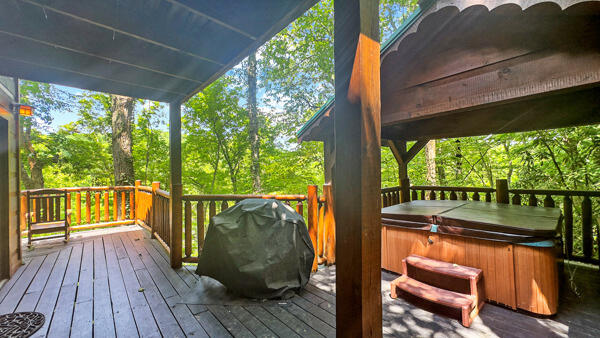 wooden deck with grilling area and a hot tub