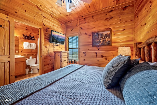 bedroom featuring wooden ceiling, wood walls, and ensuite bathroom