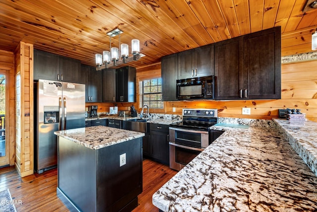 kitchen with wood ceiling, light stone counters, stainless steel appliances, and wood finished floors