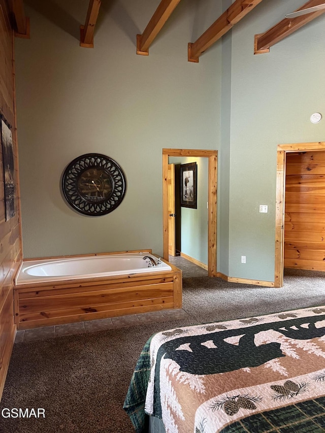 bedroom with beamed ceiling, carpet floors, and a towering ceiling