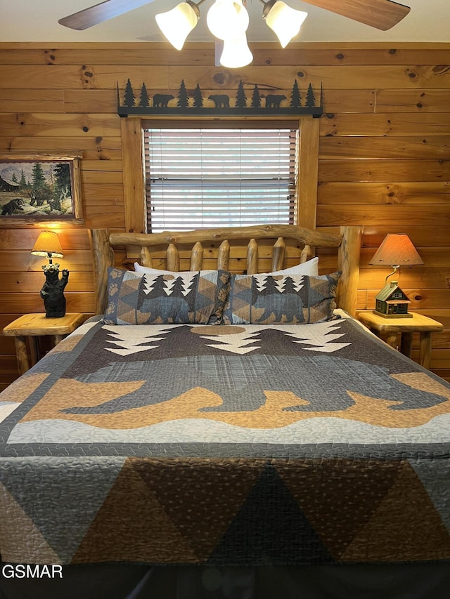 bedroom with a ceiling fan and wood walls