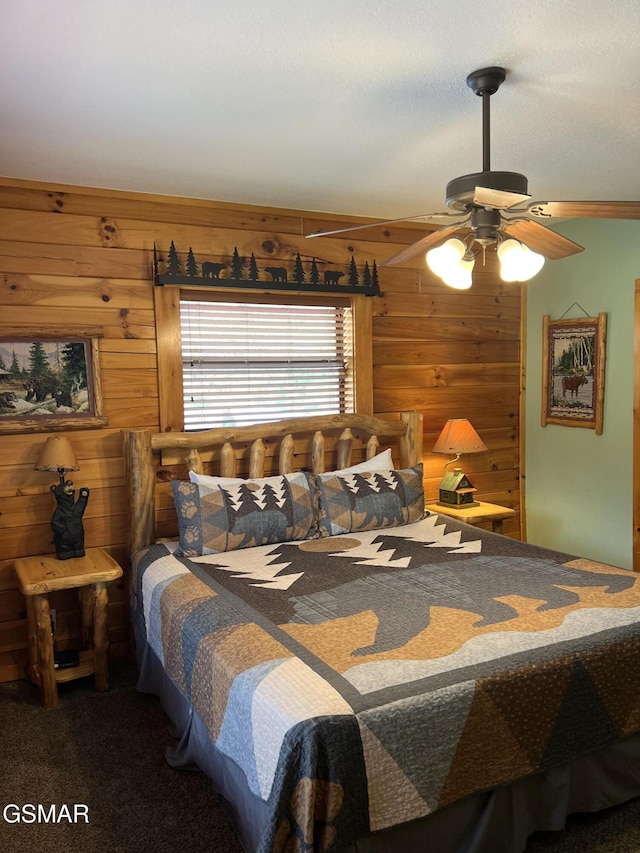carpeted bedroom with ceiling fan and wood walls