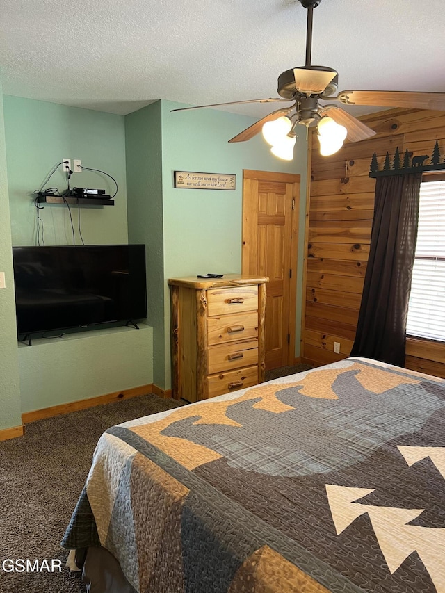 bedroom featuring ceiling fan, a textured ceiling, carpet, and baseboards