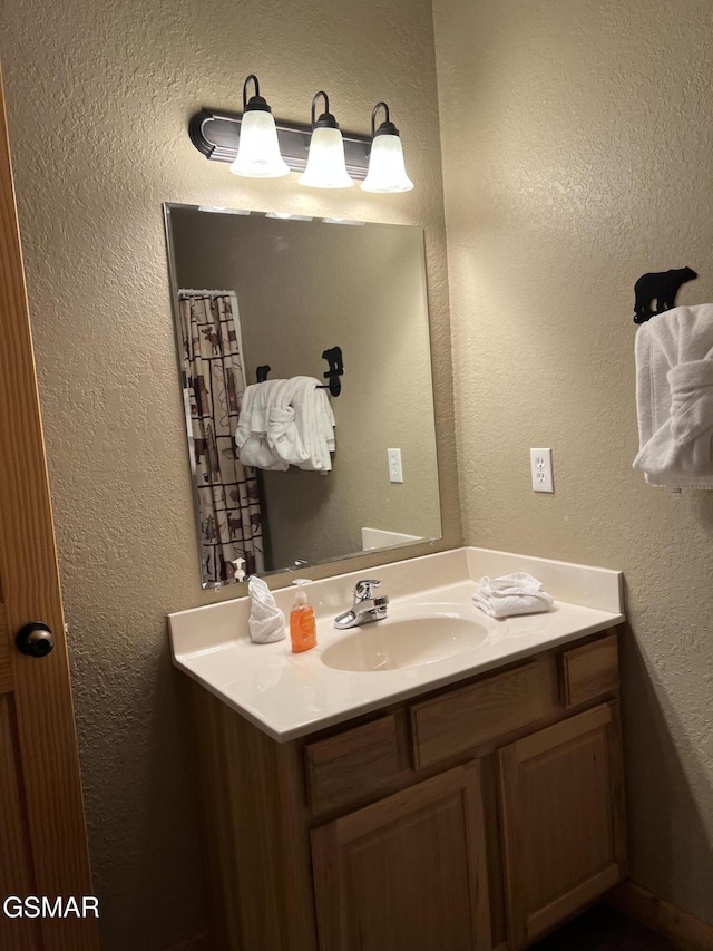 bathroom with vanity and a textured wall