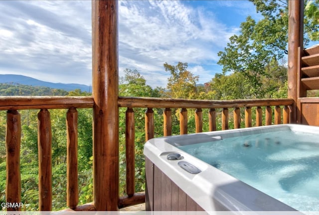 wooden terrace featuring a hot tub, grilling area, and a mountain view