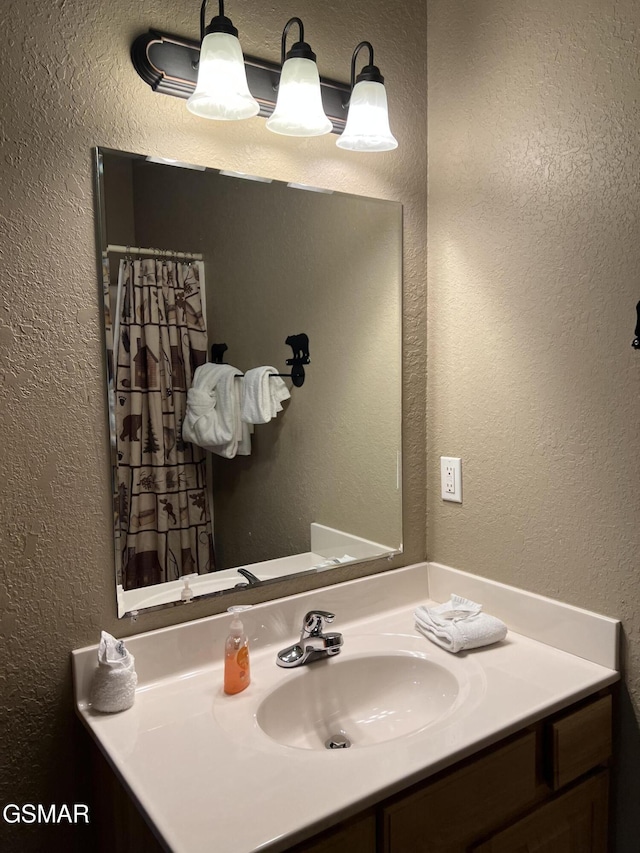 bathroom featuring vanity and a textured wall