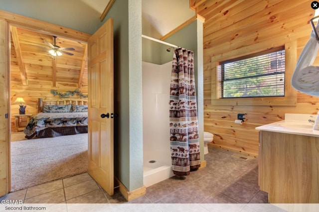 full bath with a shower stall, wooden walls, tile patterned floors, and vaulted ceiling
