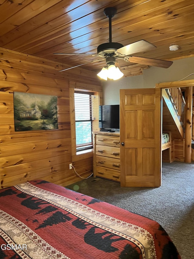 carpeted bedroom featuring ceiling fan, wooden walls, and wood ceiling