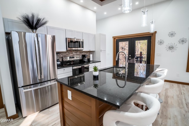 1040 Old Cartertown Rd, Gatlinburg, TN 37738 - kitchen featuring appliances with stainless steel finishes, a high ceiling, a sink, french doors, and light wood finished floors