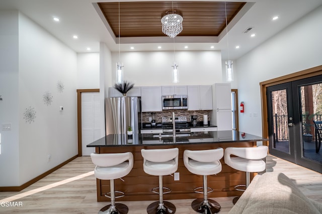 1040 Old Cartertown Rd, Gatlinburg, TN 37738 - kitchen featuring stainless steel appliances, a high ceiling, french doors, a raised ceiling, and a kitchen breakfast bar