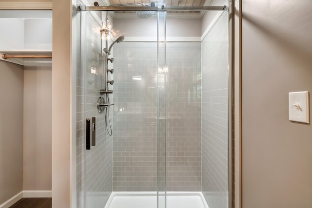 bathroom with a shower stall and baseboards