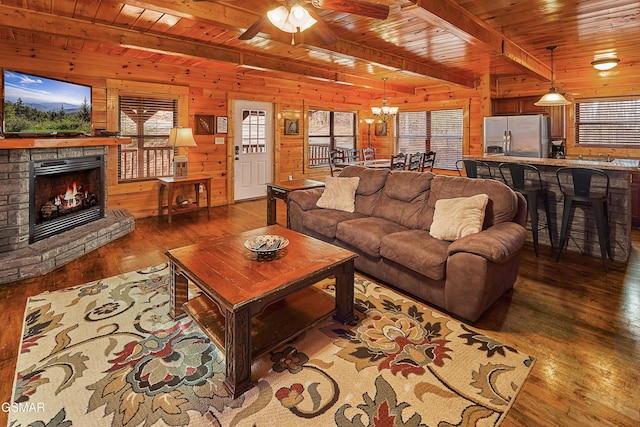 living area with wood ceiling, wood-type flooring, ceiling fan with notable chandelier, and wood walls