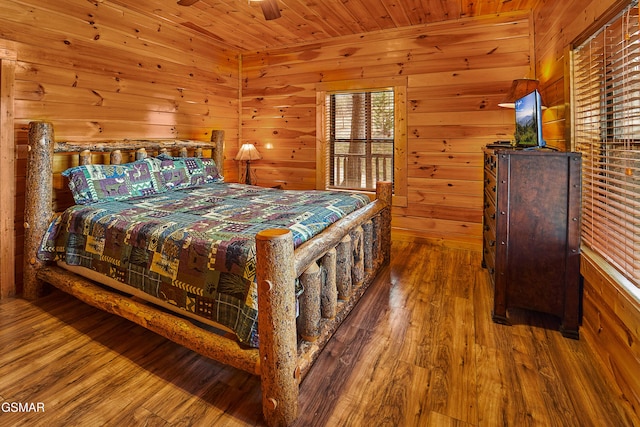 bedroom featuring wooden walls, wood ceiling, and wood finished floors