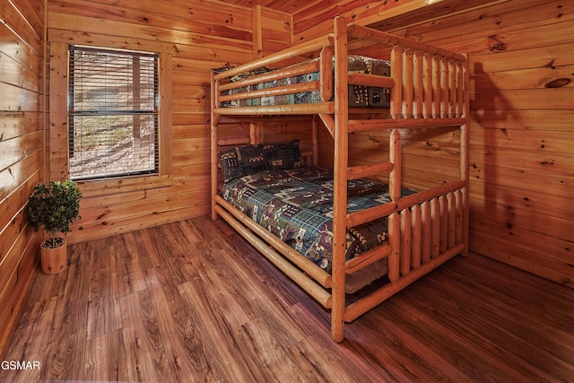 bedroom with wooden walls and wood finished floors