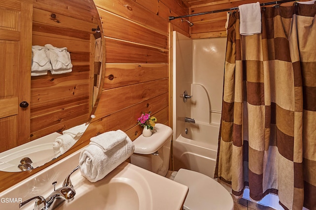 full bathroom featuring toilet, wood walls, a sink, and shower / tub combo