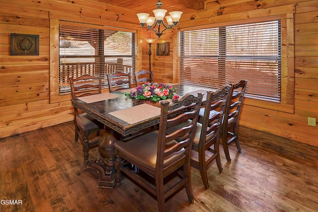 dining area featuring wood walls, wood finished floors, and a chandelier