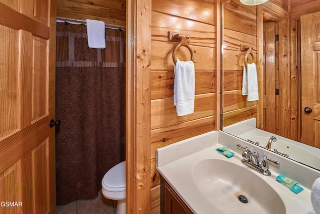 bathroom featuring wooden walls, vanity, tile patterned floors, and toilet
