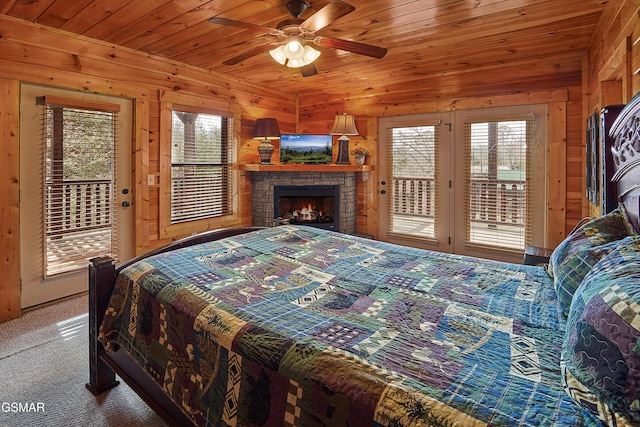 bedroom featuring carpet floors, access to outside, wood walls, and multiple windows